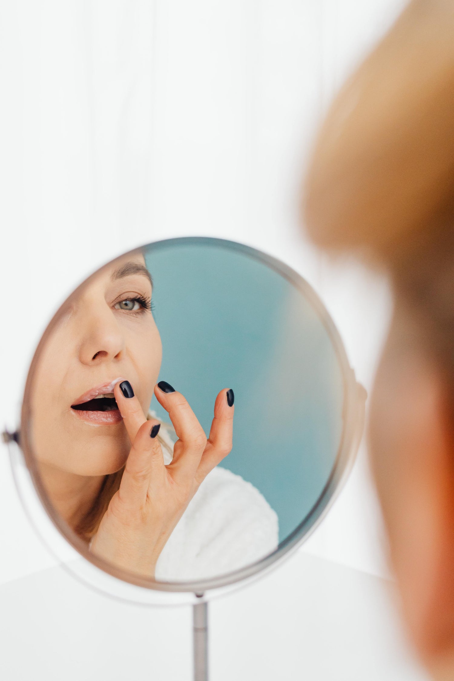 A woman applying lip balm